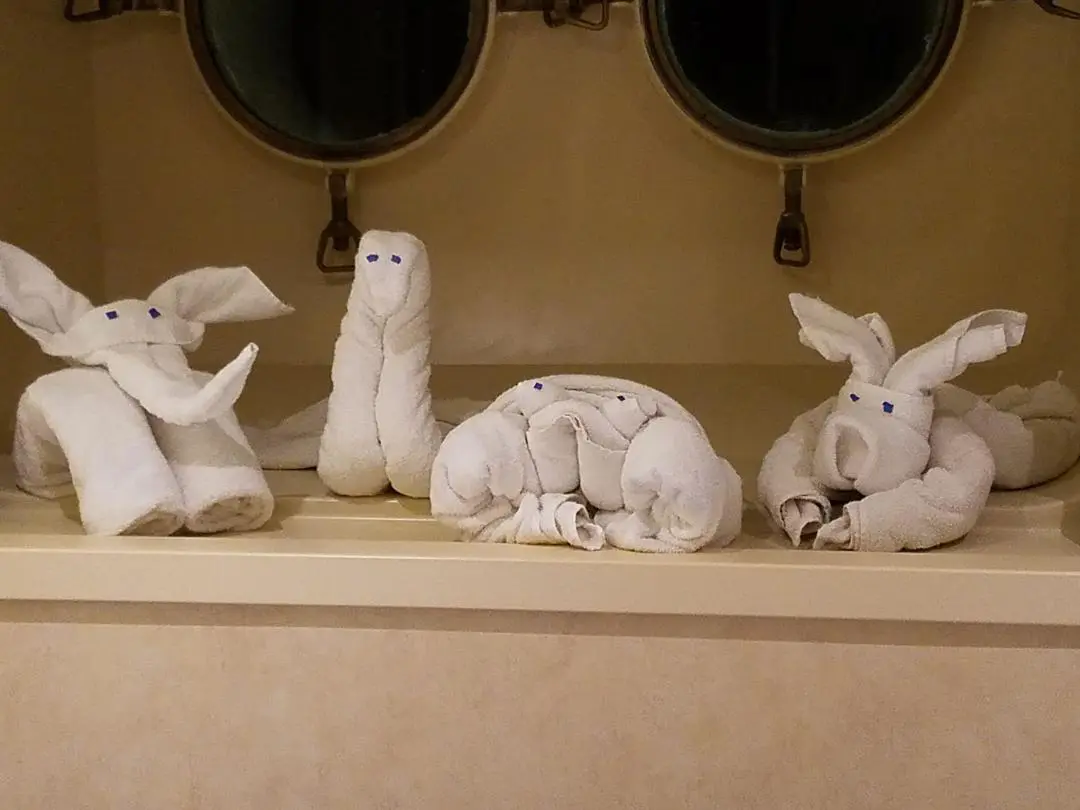A bathroom with three towels folded into the shape of animals.
