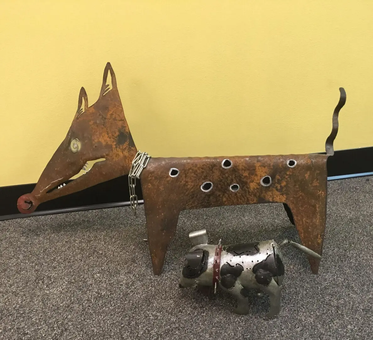A couple of metal dogs are standing on the floor